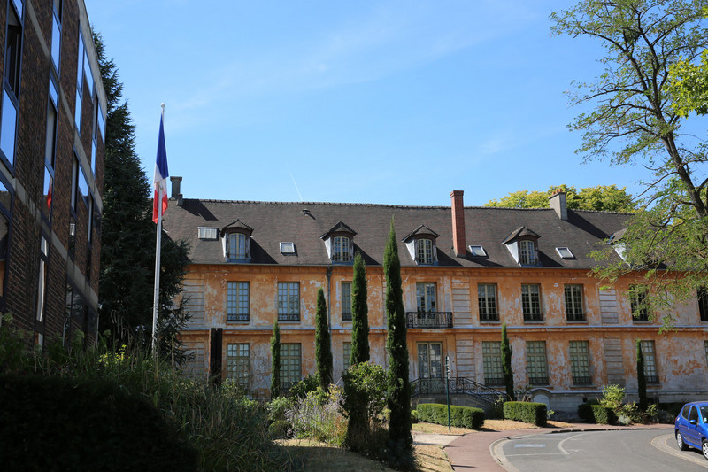Großes altes Gebäude mit der französischen Flagge im Vorgarten