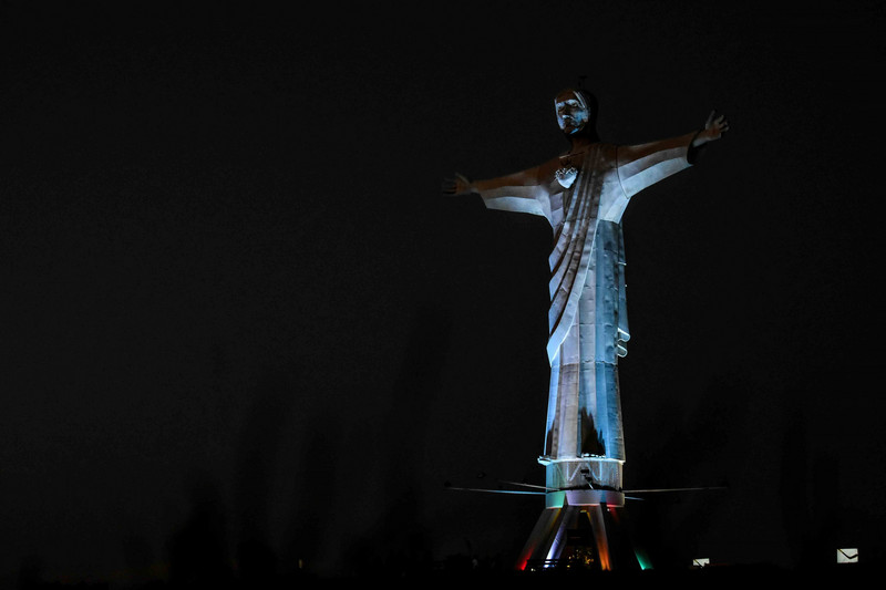 Bunt beleuchtete Statue "Christo Rey del Valle" bei Nacht