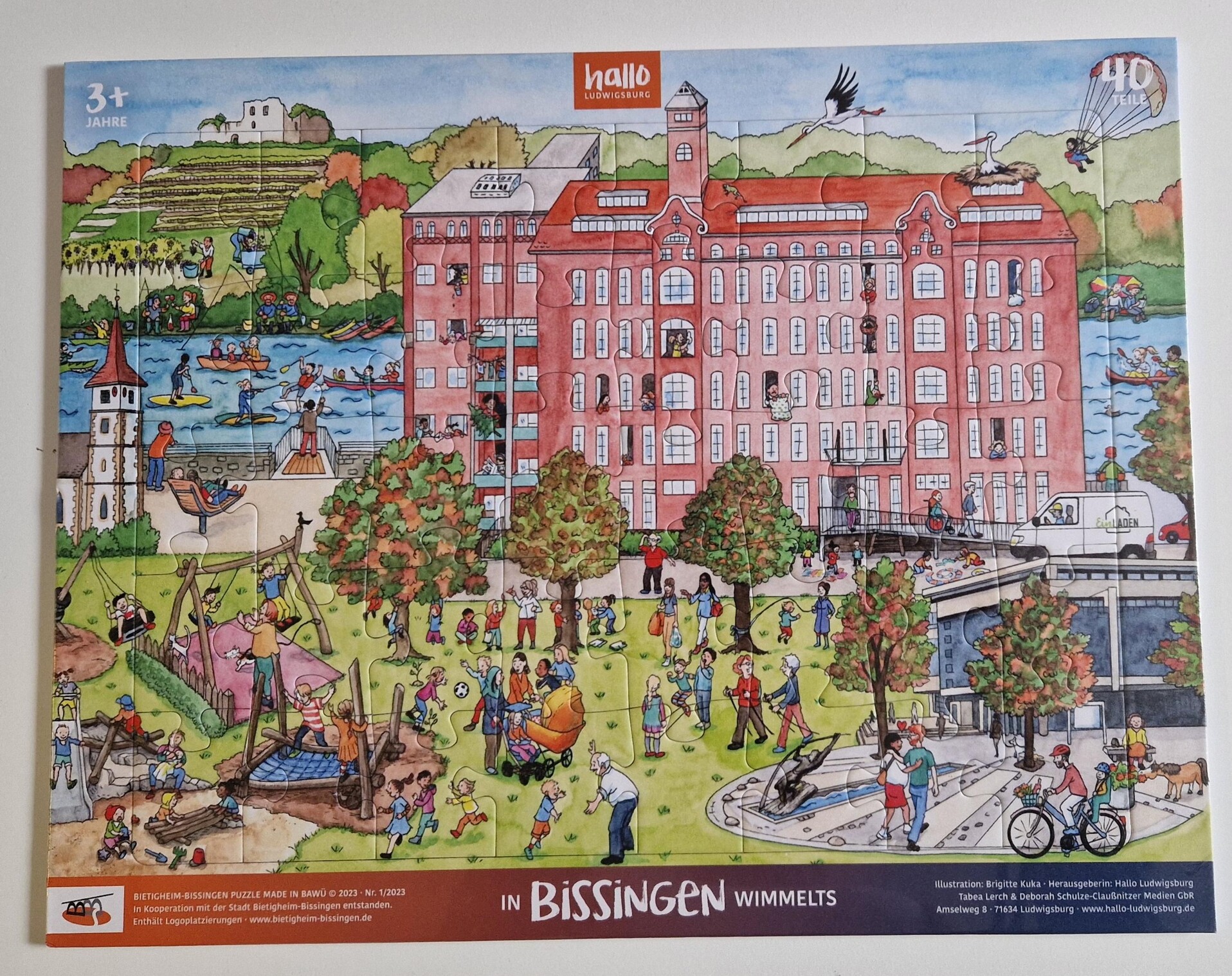 Puzzle "In Bissingen wimmelts" 40 Teile (12,99 €) Puzzle mit Aufdruck mit Gebäuden, einem Fluss und vielen Menschen