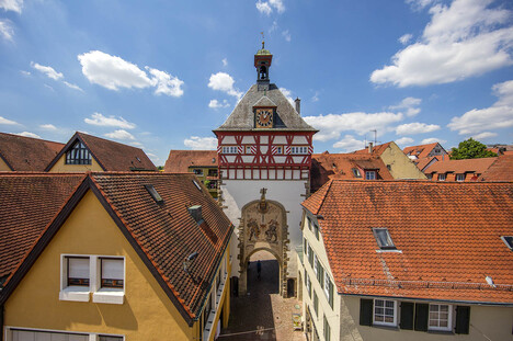 Stadttor mit vielen Haüsern unter blauem Himmel