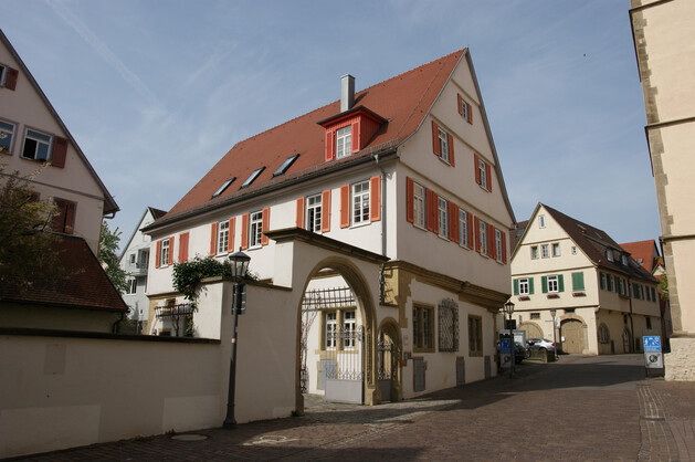 Haus mit roten Fensterläden und großem Hoftor