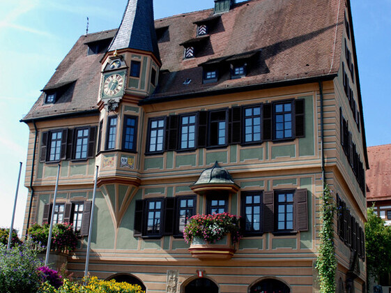 Fachwerkhaus mit Blumen geschmückt und Turmuhr