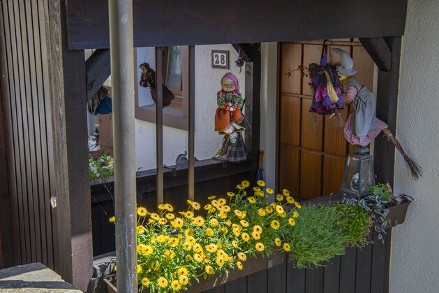 Kleine überdachte Übergänge zu den Häusern, dekoriert mit Fliegenden hexen und Blumen 