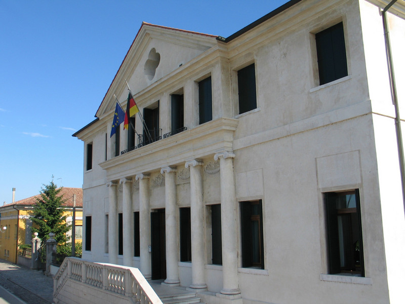 Historical building with pillars at the entrance and flags