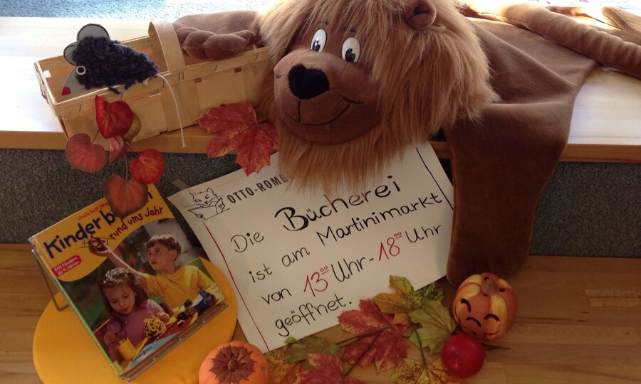 Bücher, Herbstdeko, großer Stofftierlöwe und Infoplakat zu Martinemarkt