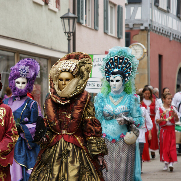 Festumzug einer Veranstaltung auf dem verschiedene Menschen zu sehen sind