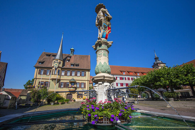 Brunnen des Marktplatzes im Hintergrund das Rathaus