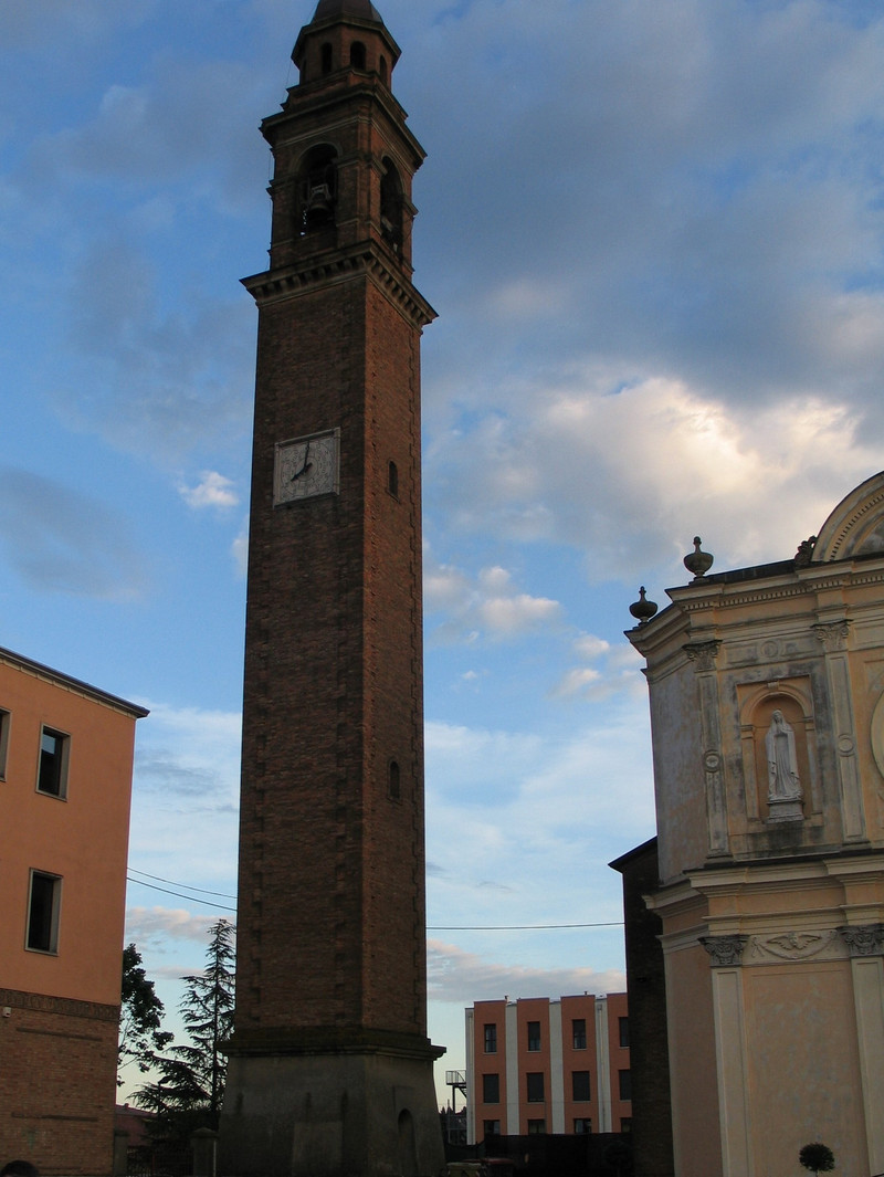 Old clocktower between buildings in the city