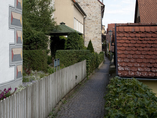 Schmaler Weg mit Blummen. Zwischen kleinen Häusern