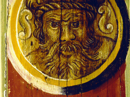 Holzbalken mit einem Gesicht in einem Kreis bemalt