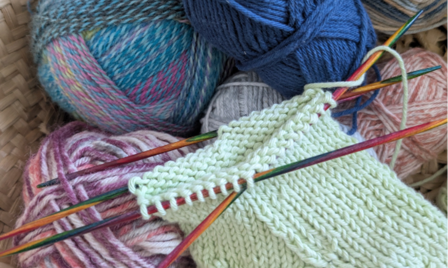 Korb mit Wolle und Strickprojekt