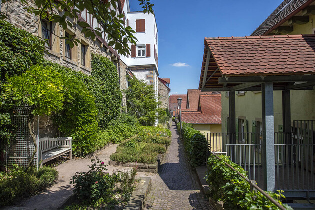 Kleiner Park an einer Stadtmauer mit Parkbank