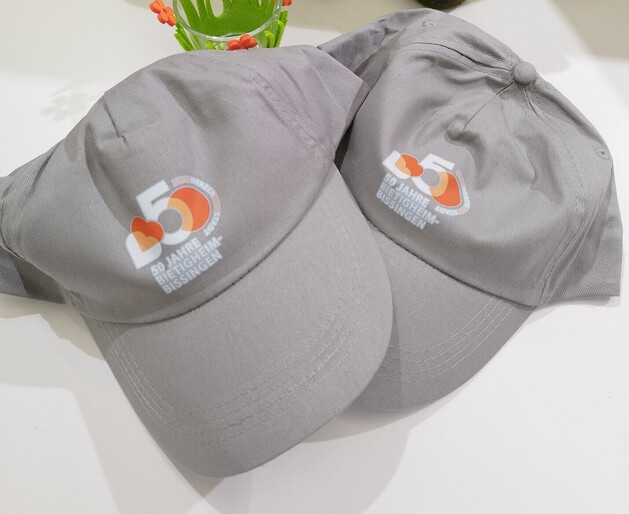 Graue Schildmütze mit einem orange/weißen Logo aufgedruckt